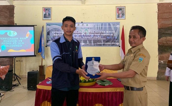 Chrysmawan bagus Handoyo menyerahkan plakat sebagai kenang-kenangan kepada Kepala Desa Kenteng